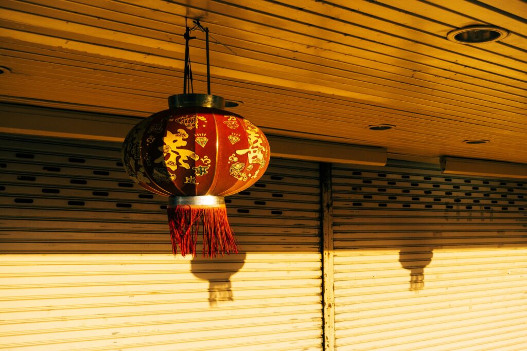 A traditional red Chinese lantern casts a warm glow, symbolizing celebration and culture.